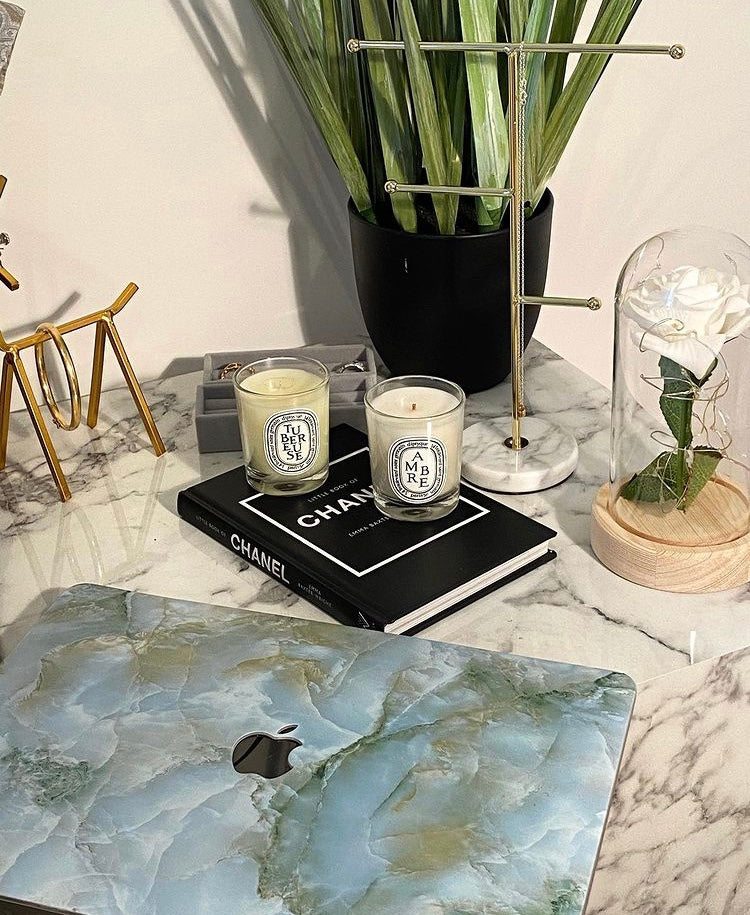 coque macbook en marbre vert sur un meuble en marbre blanc et décoration luxueuse