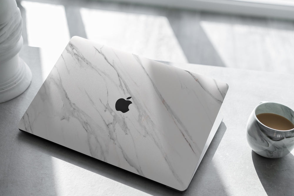 coque macbook en marbre blanc de carrare dans un bureau luxueux