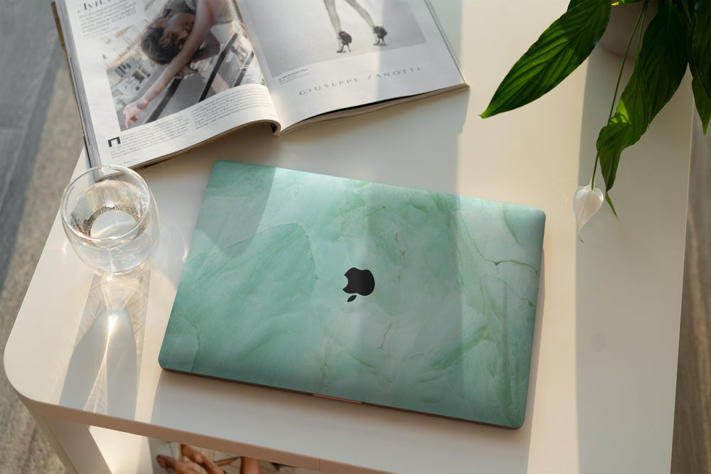 coque macbook marbre vert sur un bureau 